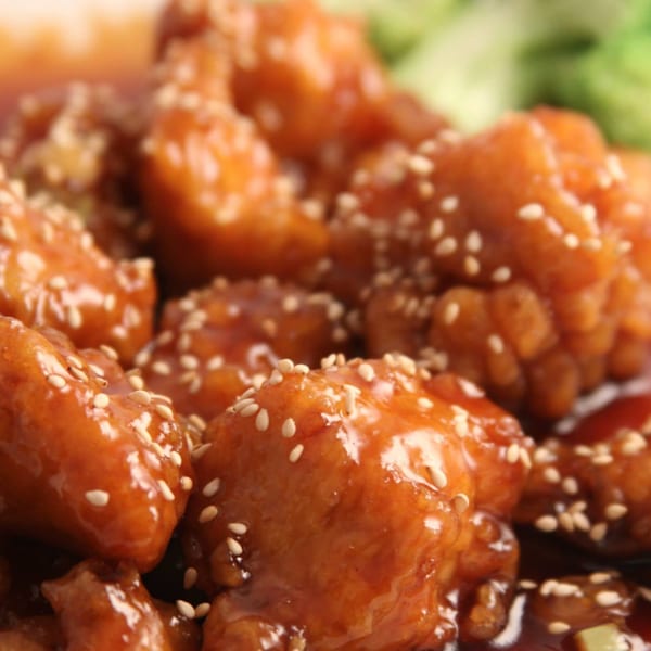 Close-up of Fulin's Asian Cuisine's sesame chicken, glistening with sauce and sprinkled with sesame seeds.