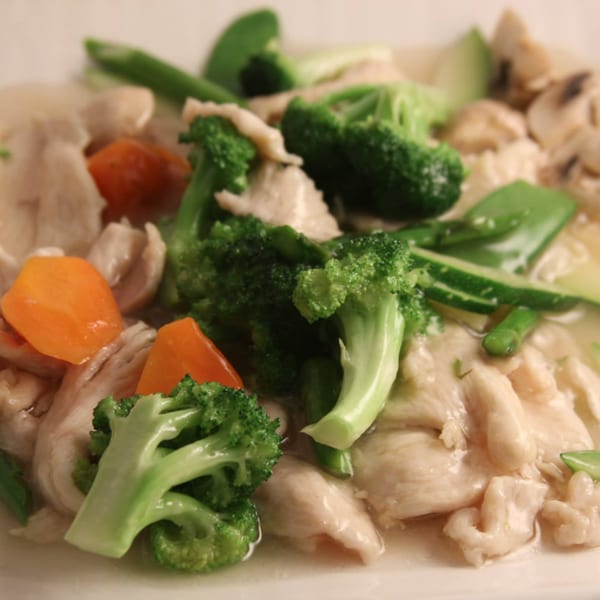 Chicken with broccoli, carrots, mushrooms, and snow peas in a light sauce.