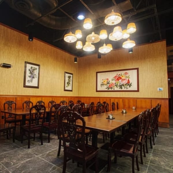 Fulin's Asian Cuisine dining room with long wooden tables, ornate chairs, and decorative wall art.